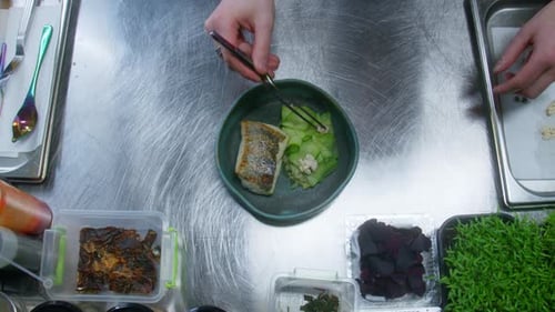 Chef Arranges Fish Dish with Gourmet Ingredients