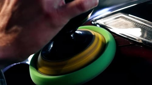 Closeup of the Hands of a Car Mechanic at a Service Station Doing the Final Polishing to Shine