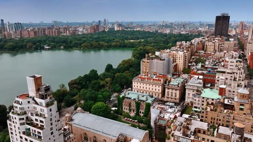 Footage over the tops of residential houses surrounding the beautiful Central Park.