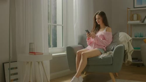 Woman Relaxing at Home Using Mobile Phone