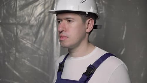 Man Puts on Mask with Hard Hat