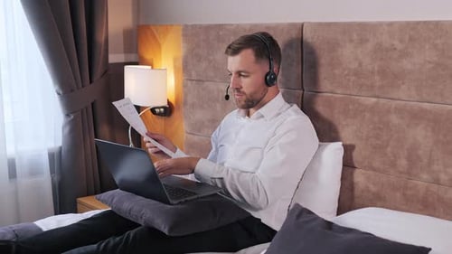 Man Working from Home Using Laptop and Headset