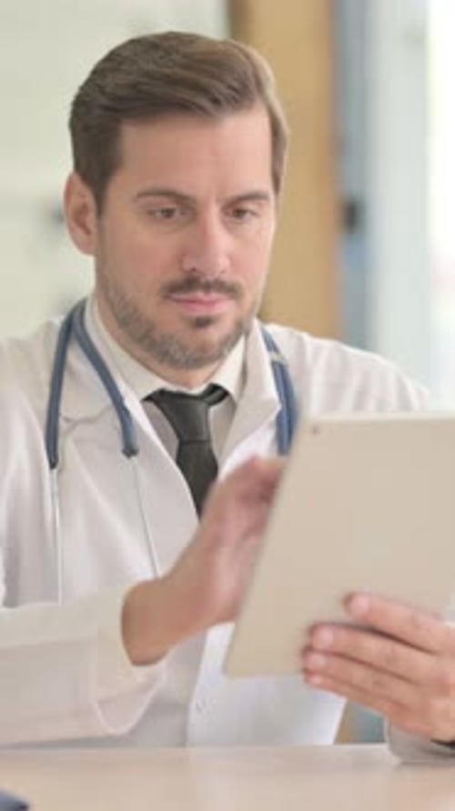 Male Doctor using Tablet in Clinic, vertical video