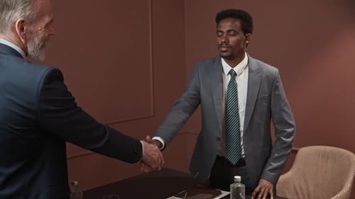 Diverse Businessmen Shaking Hands while Closing Deal Meeting at Office