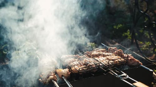 Braten von frischem saftigem Fleisch in brennender Holzkohle Feuer im Grillkorb