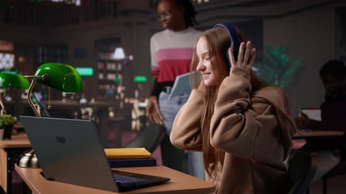 Girl Studying in the Library to Obtain Her Diploma with Focus Music on Headset