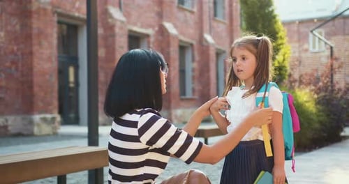 First day of school. Happy family concept. Back to school. Mother preparing and caring girl