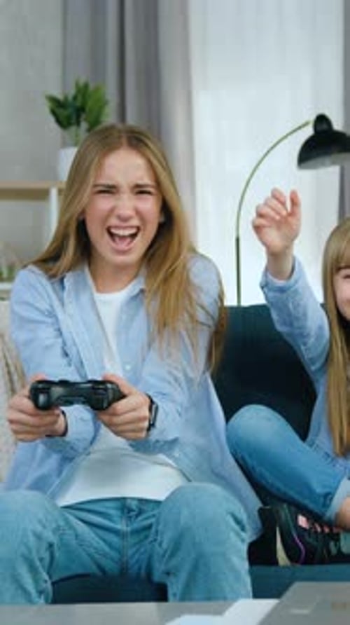 Teen and Child Play Video Games on Couch