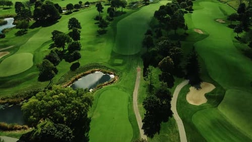 Aerial drone forward moving shot over a green golf club in Northbrook Illinois, USA at daytime.