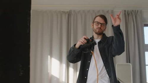 Male Photographer Taking Pictures of Model on DSLR Camera in Studio