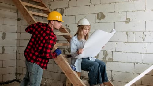 Team of Professionals Analyzing Blueprints Inside Building Under Construction