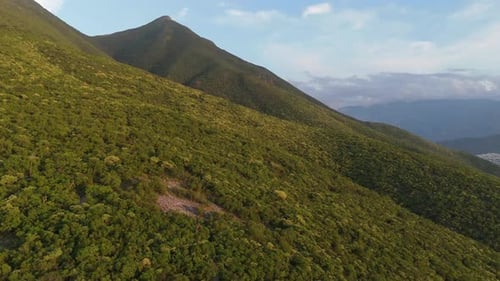 Large mountain with green meadow and a very beautiful valley on the horizon with little cloud cover