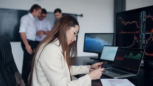Team of stockbrokers works together in modern office at daytime