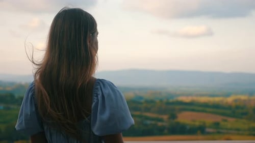 Woman Gazing at Scenic Landscape at Sunset