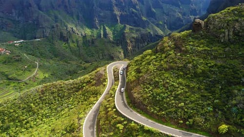 Cars Driving Through Sharp Turn on Winding Zig Zag Serpentine Road in Mountains