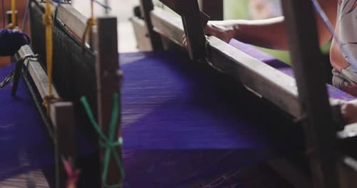 An elderly Thai woman weaves clothes and produces hand-woven according to ancient tradition. Conce