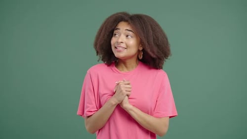 Dreamy Woman in Pink T-Shirt Posing on Green Background