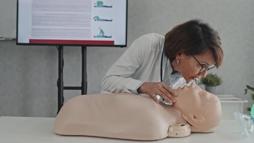 Medical Professional Demonstrates Rescue Breathing on Mannequin