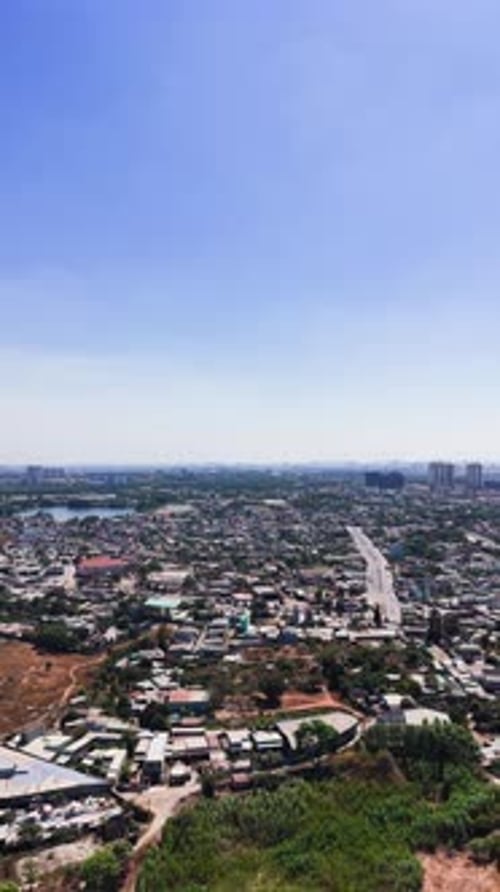View of the city from a high point showing houses, streets, and buildings under a clear sky on a