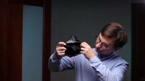 Büroangestellter überprüft leere Brieftasche und hat finanzielle Probleme