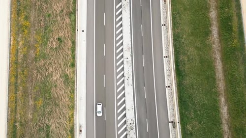Aerial Perspective of Two Cars Driving on a Divided Twolane Highway in the Countryside