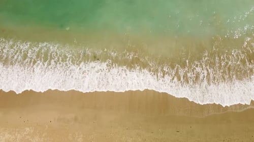 Awesome aerial view of sand beach and white crested waves