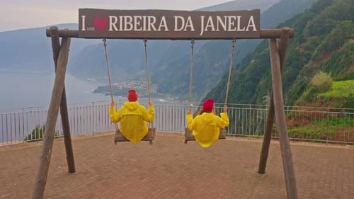 Matching Raincoats on Swings Overlooking Ribeira da Janela