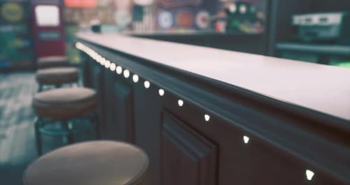 Detailed View of a Bar Counter with Decorative Lighting in a Lively Setting