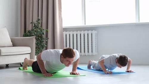 Father and Son are Doing Pushups and Having Fun at Home Diverse Family Sporty Toned Dad and Boy