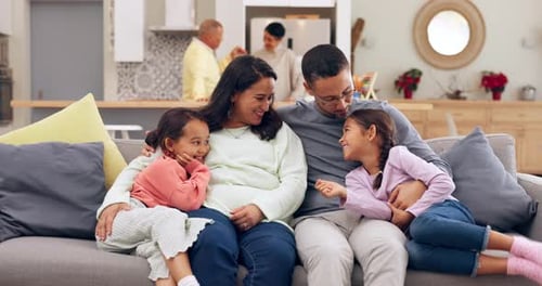 Happy Family Laughing Together on Sofa