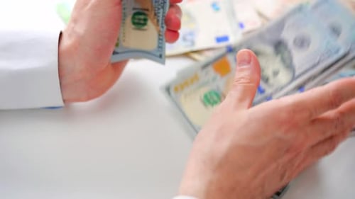 Hands Counting One Hundred Dollar Bills