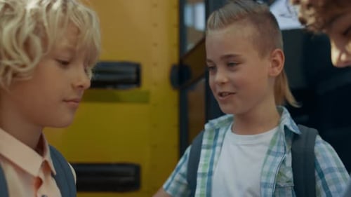Three Elementary Age Children Standing at Open Bus Door Close Up. Teen