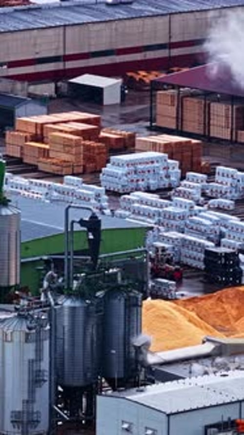 Industrial Sawmill Yard with silos and Lumber Stacks, vertical pan