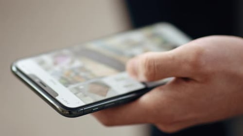 Guy Scrolling Social Media News Feed on Smartphone