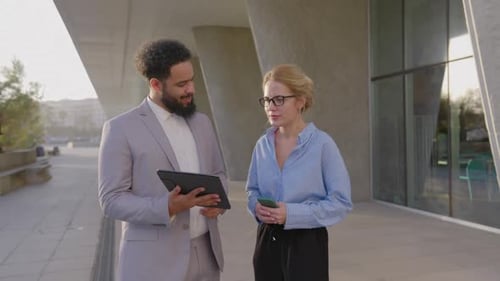 Business Professionals Discussing Tablet Near Urban Building