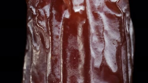 dried date rotates, on a black background close-up. In move