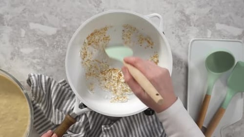 Kokosflocken in einer weißen Pfanne mit Antihaftbeschichtung Schritt für Schritt flach anrösten