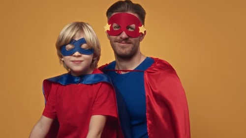 Studio Portrait of Father and Son Dressed up in Superheroes