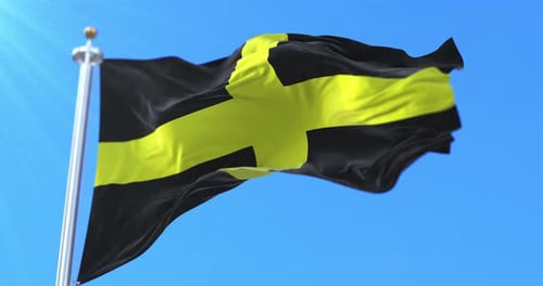 Realistic Black and Yellow Cross Flag Waving Against Blue Sky