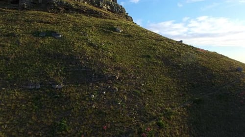 Drone, mountain and blue sky outdoor in nature with grass field, ocean and natural environment