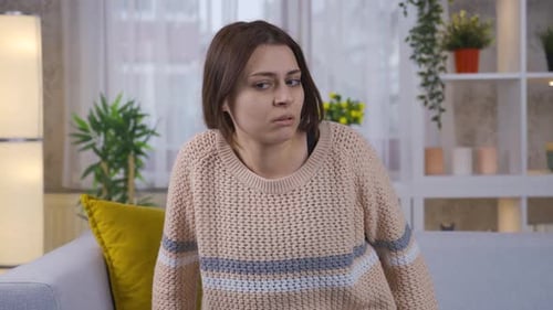 Paranoia Young woman looking around at home in fear and panic.