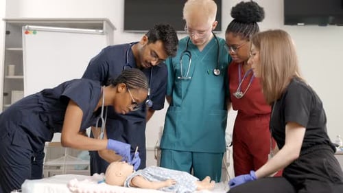 Medical Students Practicing on Baby Doll in Classroom
