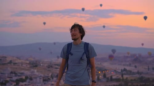 A Young Man Tourist is Looking at Hot Air Balloons in Cappadocia Turkey Happy Travel in Turkey