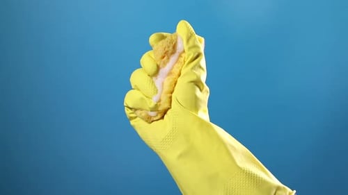 Hand in Yellow Glove Squeezing Soapy Sponge