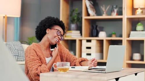 Woman Working at Computer Answering a Phone Call