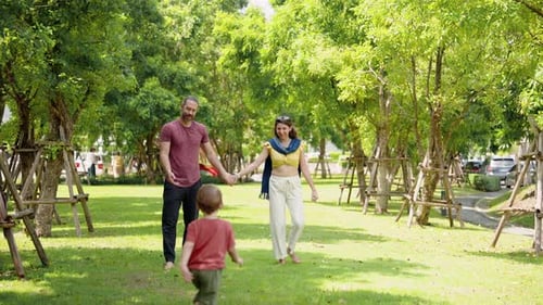 Adorable Caucasian boy is playing with his father and mother in the village grass. father with