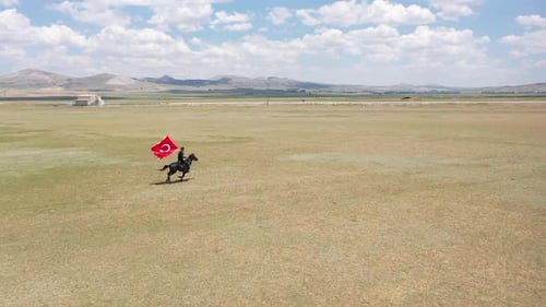 Lone Rider Galloping with Flag in Vast Field