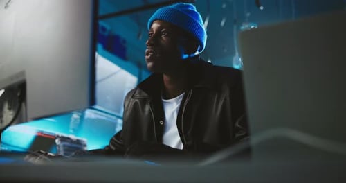 Computador, noturno e homem negro codificando no escritório para programação, atualização de software e cibersegurança