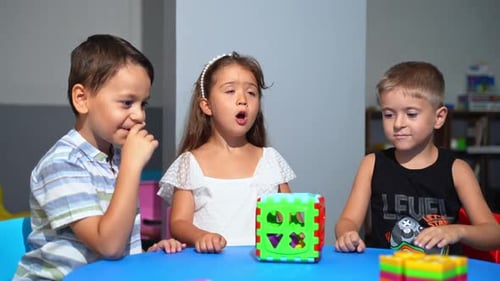 Happy Diverse School Children Having Educational Class Sitting At Desk In Classroom At School Or