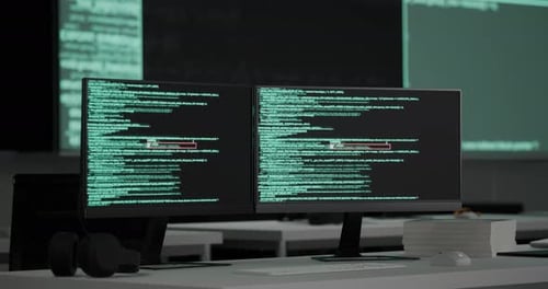 Desktops Showing Code Moving On Black Screen Background On The Table In Front Of Multiple Monitors
